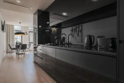 a large kitchen with black cabinets and a dining room at Urban Luxury Apartment, Downtown Porto near Metro in Porto