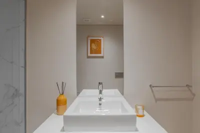 a white bathroom with a sink and a vase at Urban Luxury Apartment, Downtown Porto near Metro in Porto