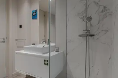 a white bathroom with a sink and a shower at City Luxury Apartment, Downtown Porto near Metro in Porto