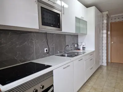 a kitchen with white cabinets and a sink at Pretty flat with terrace, air cond, free parking, by Porto with Love LDA in Porto