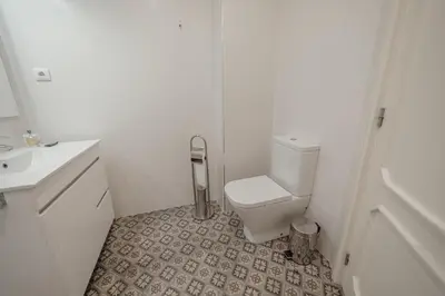 a white bathroom with a toilet and a sink at Downtown Design Apartment With Balcony by Vacationy in Porto