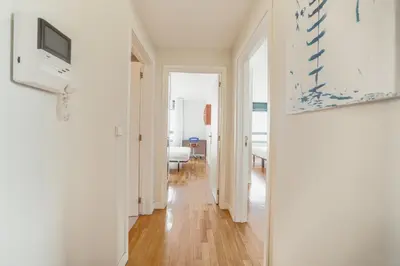 a hallway with white walls and a television in a room at Downtown Grand Tower View by Vacationy in Porto