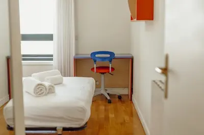 a room with a bed and a blue chair at Downtown Grand Tower View by Vacationy in Porto