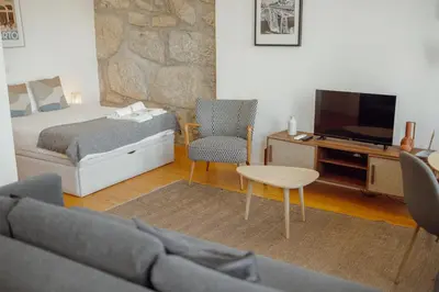 a bedroom with a bed and a tv and a couch at Courtyard Oporto Design Apartments by Vacationy in Porto