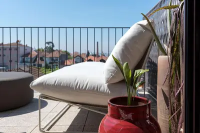 a white bed on a balcony with a potted plant at Boavista Penthouse w/ 2 Balconies & AC by LovelyStay in Porto
