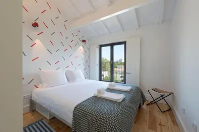 a bedroom with a white bed and a table at Boavista Penthouse w/ 2 Balconies & AC by LovelyStay in Porto