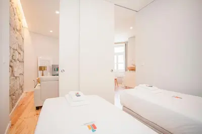 a white room with two beds and a couch at Liiiving in Porto - Aliados Stone Apartment in Porto