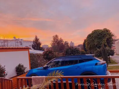 a blue car parked on a balcony with a sunset at Paraíso Garden Suite--- Spacious & Downtown in Porto