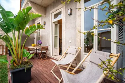 a patio with chairs and a table on a porch at Paraíso Garden Suite--- Spacious & Downtown in Porto