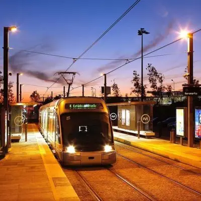 a train traveling down the tracks at night at Downtown A whole house duplex designed for remote work and near metro lapa in Porto