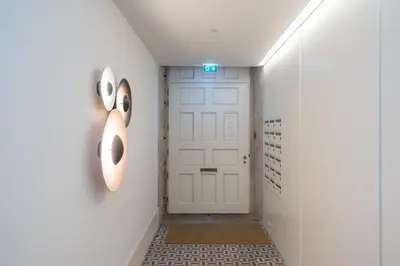 a hallway with a white door and a sign on the wall at Infante Apartment by Amber Star Rent in Porto