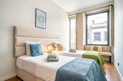 two beds in a room with two windows at Art City Villa in Porto