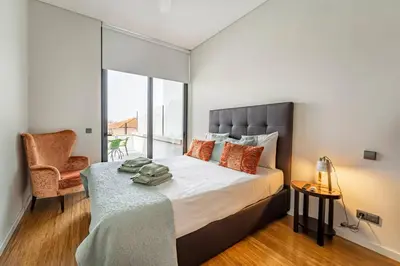 a bedroom with a large bed and a chair at Art City Villa in Porto