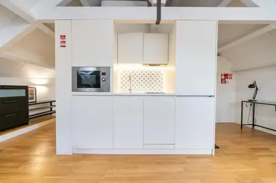 a living room with white ceilings and a blue couch at Mercadores Apartment by Amber Star Rent in Porto