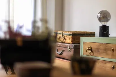 a desk with a lamp on top of a dresser at Voga Apartments Sta Catarina in Porto