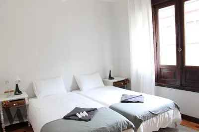 two beds in a room with white walls and a window at Voga Apartments Sta Catarina in Porto