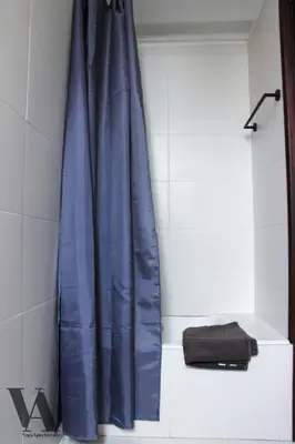 a blue shower curtain in a white bathroom at Voga Apartments Sta Catarina in Porto