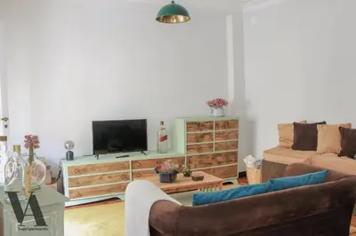 a living room with a couch and a tv at Voga Apartments Sta Catarina in Porto