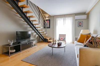 a living room with a couch and a staircase at My homey at Flores in Porto