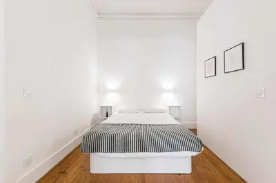 a white bedroom with a bed in a white room at Classic Bonjardim in Porto