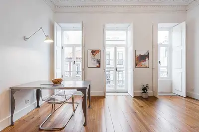 a dining room with a table and some windows at Classic Bonjardim in Porto
