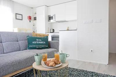 a living room with a couch and a table with food on it at Stylish Flat W/ Gym & Parking by LovelyStay in Porto