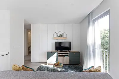 a living room with a couch and a tv in a room at Stylish Flat W/ Gym & Parking by LovelyStay in Porto