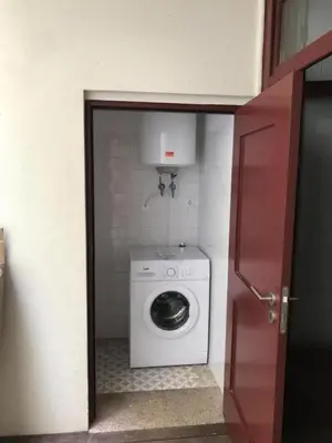 a washer and dryer in a corner of a room at Pateo Loft in Porto