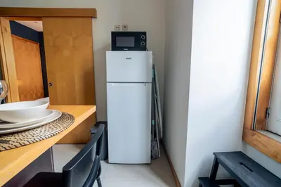 a white refrigerator with a microwave on top of it at Blue Studio perto do metro - Cedofeita, Porto in Porto