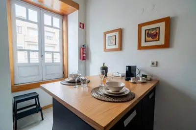 a kitchen with a wooden counter top with wine glasses at Blue Studio perto do metro - Cedofeita, Porto in Porto