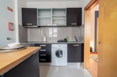 a kitchen with a washing machine in a kitchen at Blue Studio perto do metro - Cedofeita, Porto in Porto