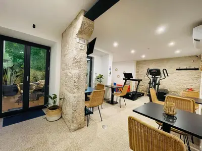 a living room with a stone pillar and tables and chairs at Lindo apartamento em zona central, Batalha - Porto - APT L in Porto