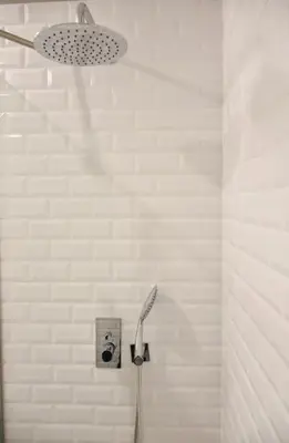 a bathroom with a shower with a white tile wall at Lindo apartamento em zona central, Batalha - Porto - APT L in Porto