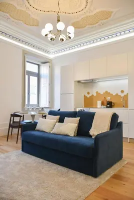 a blue couch in a living room with a table at Apartamento encantador na Batalha - Porto - APT E in Porto
