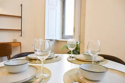 a table with plates and wine glasses on it at Apartamento encantador na Batalha - Porto - APT E in Porto