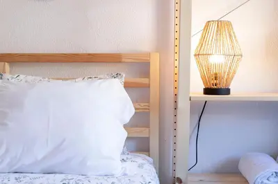 a bed with a white pillow and a lamp on a shelf at Travel & Live Nature in Porto