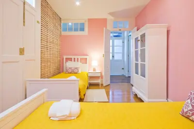 a small room with two beds and a hallway at Porto Sé Apartamentos in Porto