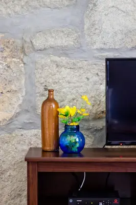 a table with a bottle and a vase with flowers at Porto Sé Apartamentos in Porto