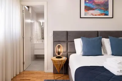 a white bedroom with a bed and a mirror at Invicta Premium - 4BR Downtown apartment with AC in Porto