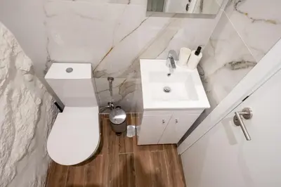 a bathroom with a white toilet and a sink at Entire House with 4 Master Suites, Hot Tub & Backyard - Central Location in Vila Nova de Gaia