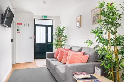 a living room with a gray couch and plants at Entire House with 4 Master Suites, Hot Tub & Backyard - Central Location in Vila Nova de Gaia