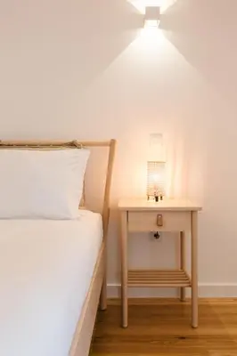 a bed and a table with a lamp on it at ORM Prado Apartment in Porto