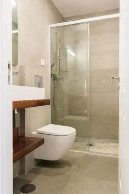 a bathroom with a toilet and a glass shower at ORM Prado Apartment in Porto