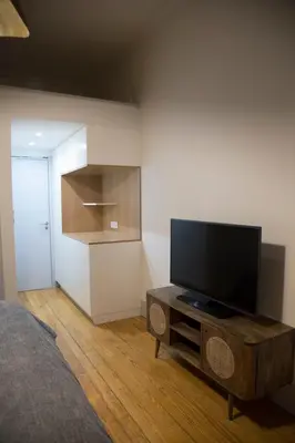 a bedroom with a flat screen tv on a wooden table at TOP Porto in Porto