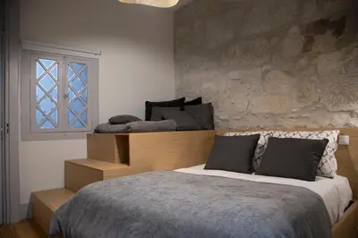 a bedroom with a bed and a stone wall at TOP Porto in Porto