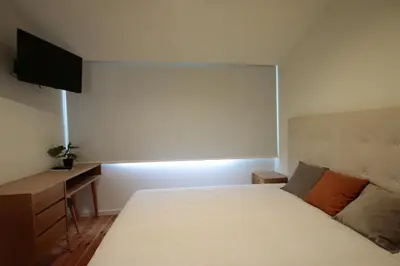 a bedroom with a bed and a desk and a television at OPORTO GUEST Natária Flats with Parking in Porto