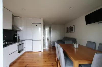 a kitchen and living room with a wooden table and a dining room at OPORTO GUEST Natária Flats with Parking in Porto
