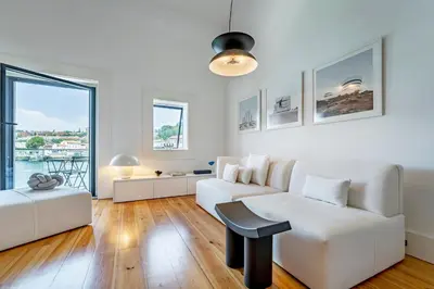 a white bedroom with a bed and a staircase at Art Douro Historic Distillery in Vila Nova de Gaia