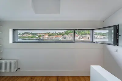 a room with a white chair and a floor lamp at Art Douro Historic Distillery in Vila Nova de Gaia