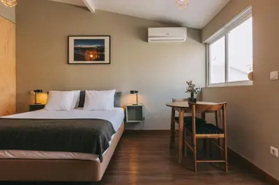a bedroom with a bed and a table and a window at Oporto Maison Sol in Porto